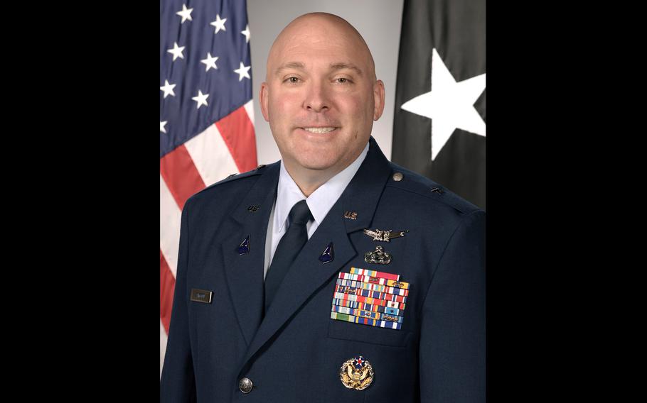 A man in formal military attire smiling for a portrait.