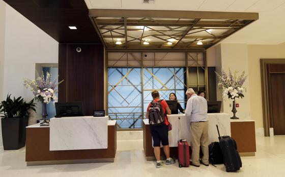 In this Sept. 5, 2018, file photo guests stand at the front desk at the Embassy Suites by Hilton hotel in Seattle's Pioneer Square neighborhood in Seattle. In the 1990s and early 2000s, hotels began offering 100% Satisfaction Guarantees to customers. The promise ensured that customers who were dissatisfied with their service would be guaranteed full refunds with no questions asked. Fast forward to 2022, and it looks like this prevailing expectation has had a negative impact on the overall hotel experience for customers.   