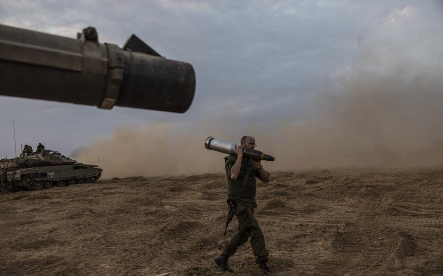 An Israeli soldier carries a tank shell near the border of Gaza on Oct. 1. The soldiers wrote messages that included "In memory of soldiers killed in the recent Hamas attack."