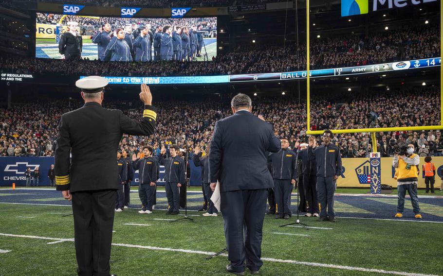 Navy Secretary Carlos Del Toro, right, and Rear Adm. Peter Garvin, commander of the Navy Education and Training Command, administer the oath of enlistment to future sailors on Dec. 11, 2021, during the Army-Navy football game held at the MetLife Stadium in New Jersey. 