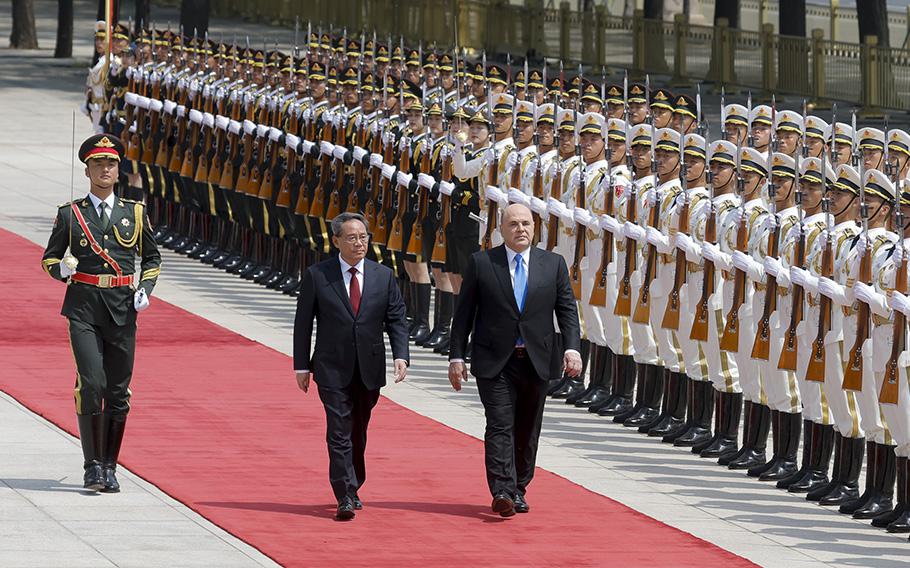Russian Prime Minister Mikhail Mishustin, right, and Chinese Premier Li Qiang attend a welcoming ceremony in Beijing, China, Wednesday, May 24, 2023. 