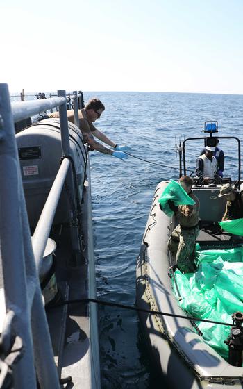 Sailors from the patrol coastal ship USS Chinook transfer weapons seized from a fishing vessel in international waters of the Gulf of Oman, Jan. 6, 2023. U.S. naval forces seized 2,116 AK-47 assault rifles from the vessel on a route from Iran to Yemen. 