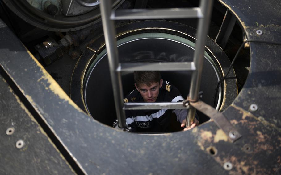 A sailor descends into a French Rubis-class submarine at the Toulon naval base in southern France, Monday, April 15, 2024. The nuclear powered submarine will be guarding France's Charles de Gaulle aircraft carrier during training exercises dubbed Neptune Strike in the Mediterranean with the 32-nation NATO military alliance.