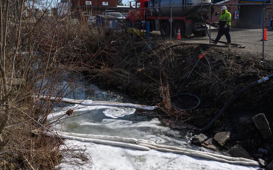 Crews work along a creek where chemicals from the derailment are present. 