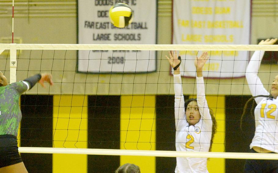 Kubasaki's Risha McGriff spikes over the double block of Kadena's Malea Williams and Malana Williams during Thursday's Okinawa volleyball match. The Dragons beat the Panthers in straight sets for the 11th time this season.