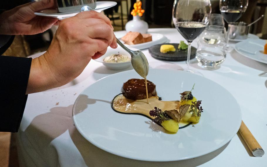 Le Chat-Botte, Michelin star restaurant at the Beau Rivage, pouring sauce over a selection from the game menu. 