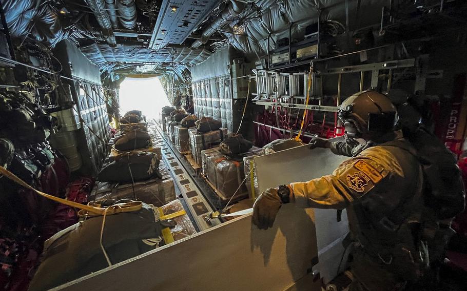 The loadmaster on a U.S. Air Force C-130 cargo plane looks out the open bay door at the Mediterranean Sea prior to an airdrop of humanitarian aid into northern Gaza on Wednesday, March 20, 2024.