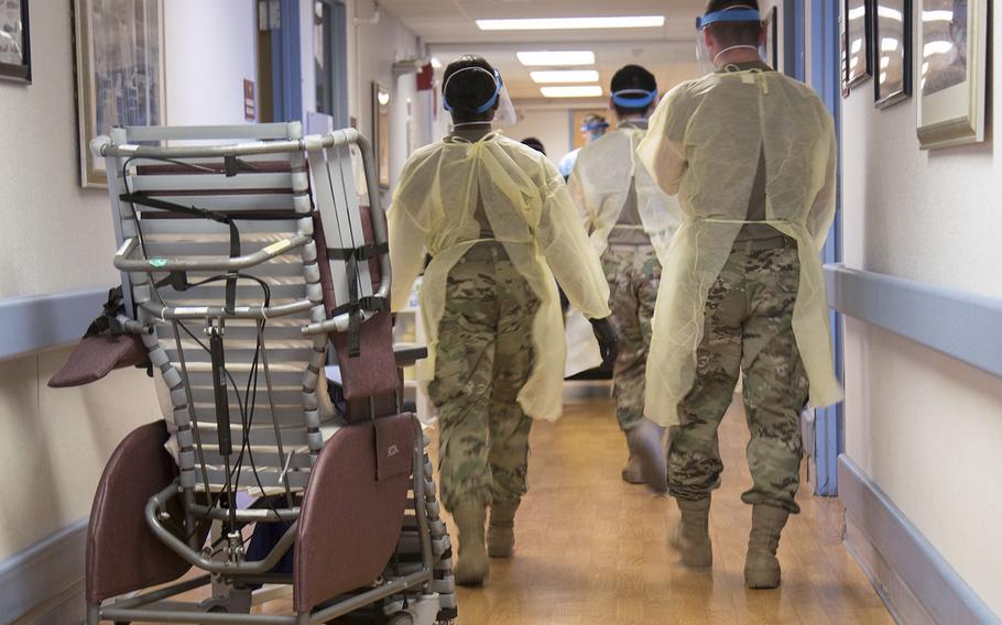 Soldiers from the Massachusetts National Guard walk down one of the halls of the Holyoke Soldiers’ Home in Holyoke, Mass., on April 1, 2020.  