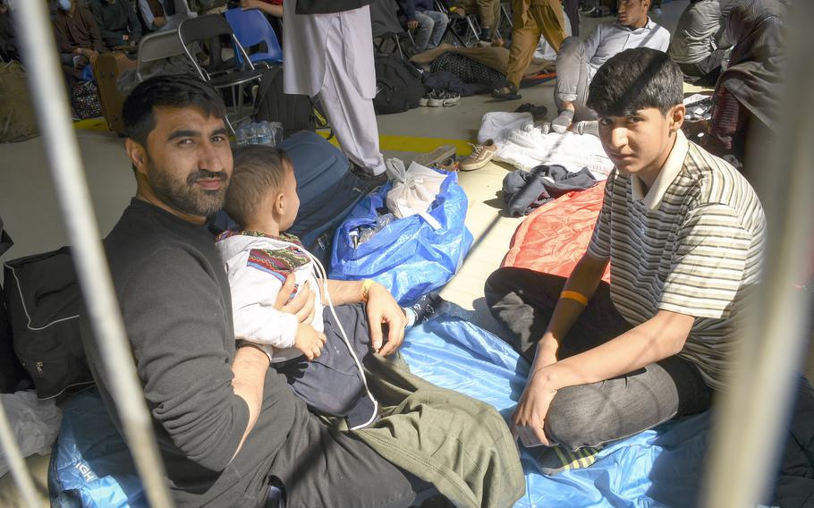 Hafizullah, a relative of U.S. Embassy staff in Kabul, Afghanistan, holds his 4-year-old son Mohammad Salah before taking a flight to the U.S. in a hangar at Ramstein Air Base in Germany on Wednesday, Sept. 1, 2021.