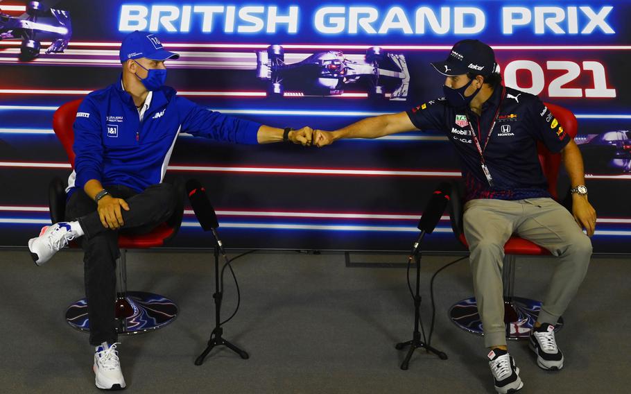 Haas driver Mick Schumacher of Germany, left, and Red Bull driver Sergio Perez of Mexico greet each other with a fist bump as they attend a media conference at the Silverstone circuit July 15 Silverstone, England. 
