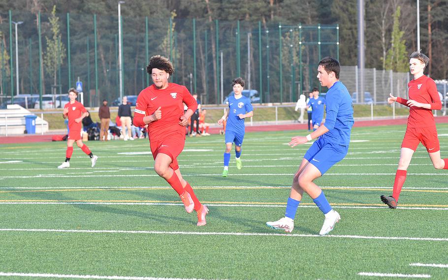 Ramstein’s Mathias Bailey slots home an early goal during the Royals’ matchup with Kaiserslautern at Ramstein High School on Ramstein Air Base, Germany. Raiders defender Jackson Armstron, left, watches.