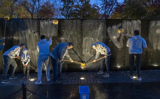 Volunteers wash the wall of the Vietnam Veterans Memorial, Saturday, Nov. 2, 2024 in Washington. The wall, about 492 feet long, took about 45 minutes to clean by the 24 volunteers. (Eric Kayne/Stars and Stripes)