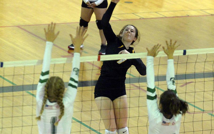 Kadena's Deniz Dussetschleger hits between Kubasaki's Emma Leggio and Grace Berrens during Thursday's Okinawa volleyball match. The Dragons won in straight sets.