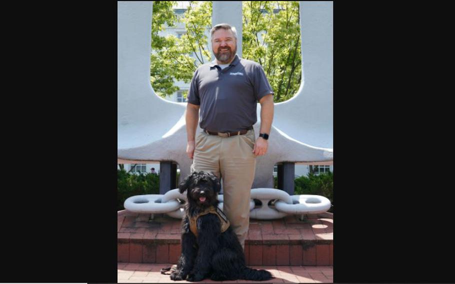 Navy civilian Luke Armstrong poses with Sammy, who was trained through Semper K9, a Virginia-based charity that turns rescued dogs into service animals for disabled veterans.