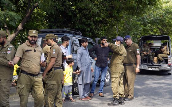 Police officers search a man at a temporary checkpoint around the home of Pakistan's former Prime Minister Imran Khan, in Lahore, Pakistan, Wednesday, May 17, 2023. Police surrounded the home of former Prime Minister Khan on Wednesday, claiming he was sheltering dozens of people allegedly involved in violent protests over his recent detention.