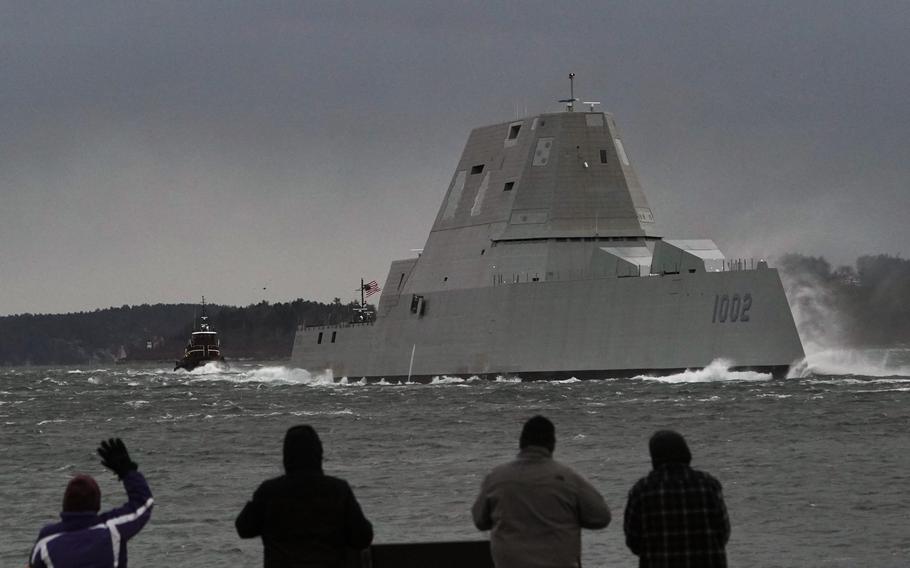 Spectators watch the USS Lyndon B. Johnson Zumwalt-class destroyer travel down the Kennebec River on its way to sea Jan. 12, 2022, in Phippsburg, Maine. The U.S. Navy, following costly lessons after cramming too much new technology onto warships and speeding them into production, is slowing down the design and purchase of its next-generation destroyer, and taking extra steps to ensure new technology like lasers and hypersonic missiles have matured before pressing ahead. 
