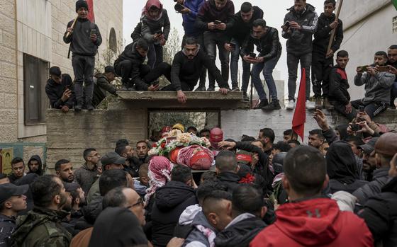 Mourners carry the body of 14-year-old Palestinian Omar Khumour during his funeral in the West Bank city of Bethlehem, Monday, Jan. 16, 2023. The Palestinian Health Ministry said Khumour died after being struck in the head by a bullet during an Israeli military raid into Dheisha refugee camp near the city of Bethlehem. The Israeli army said that forces entered the Dheisha camp and were bombarded by Molotov cocktails and rocks. It said soldiers responded to the onslaught with live fire. (AP Photo/Mahmoud Illean)