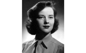 A black and white portrait of a young woman in uniform.