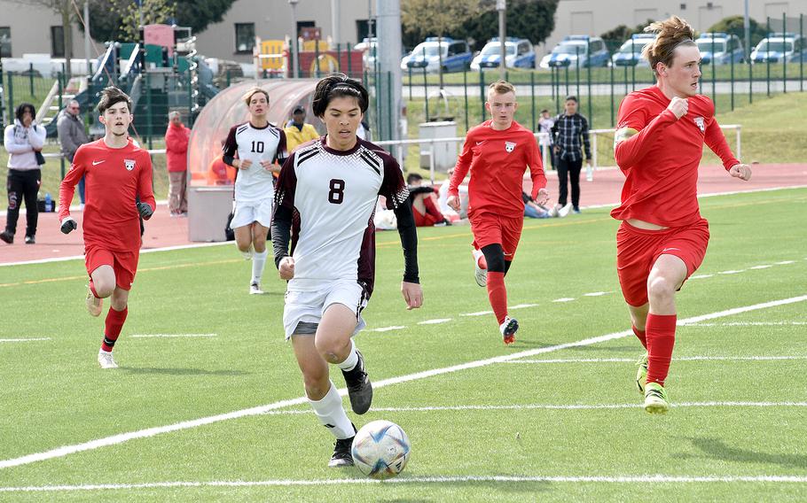 Vilseck's John Allen Koyama, center, runs behind the defense while Kaiserslautern's Brandon Patterson, right, checks for help during Saturday afternoon's match at Kaiserslautern High School in Kaiserslautern, Germany.