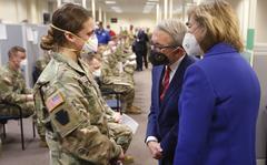 Ohio Gov. Mike DeWine, center, and his wife Fran, right, talk with specialist Emily Milosevic as they tour the Defense Supply Center Columbus in Columbus, Ohio, as members of the Ohio Army National Guard prepare to deploy to aid Ohio hospitals during the current surge in COVID-19 hospitalizations Jan. 6, 2022. Up to 40,000 Army National Guard soldiers across the country - or about 13% of the force — have not yet gotten the mandated COVID-19 vaccine, and as the deadline for shots looms, at least 14,000 of them have flatly refused and could be forced out of the service.