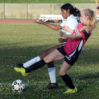 Kadena's Maddie Smalls and Kubasaki's Solares Solano scrum for the ball during Wednesday's DODEA-Okinawa soccer match. The Panthers won 3-1.