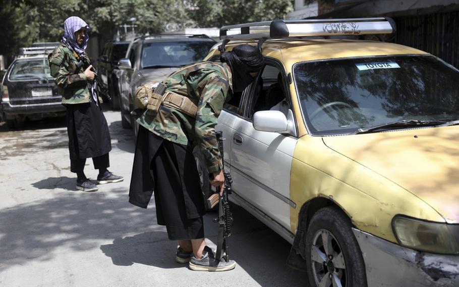 Taliban fighters search a vehicle at a checkpoint on the road in the Wazir Akbar Khan neighborhood in the city of Kabul, Afghanistan on Aug. 22, 2021. 