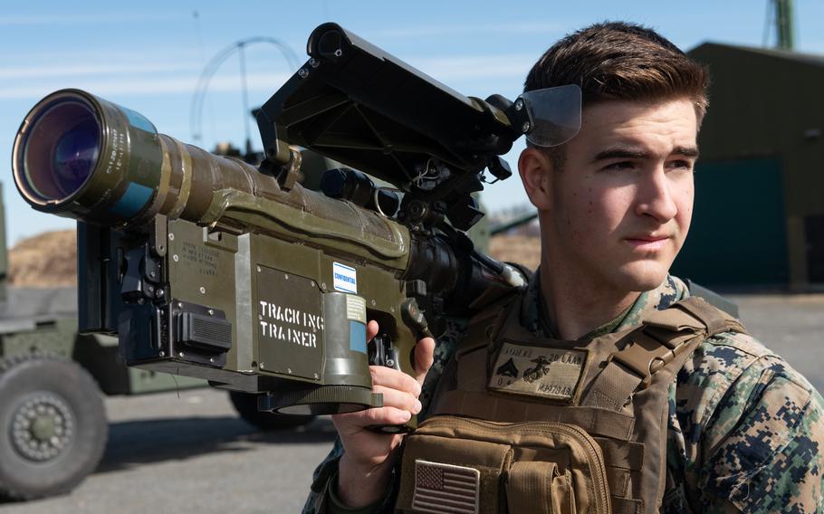 A Marine holds the missile system in his right arm.