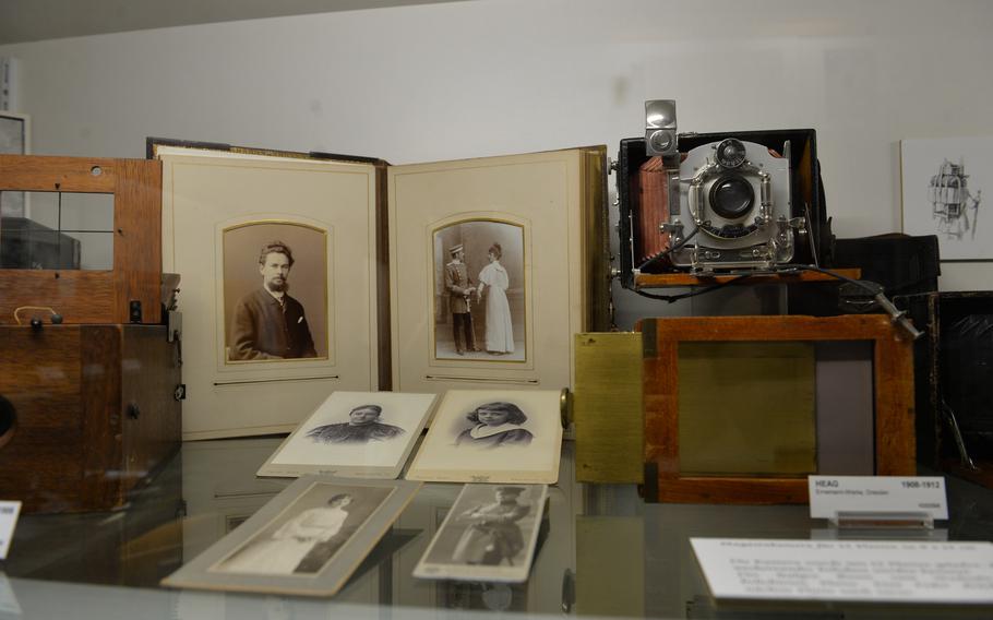 Historical portraits hang alongside examples of period camera models at the 3F German Film and Photo Technology Museum in Deidesheim, Germany, on Dec. 2, 2021. The exhibits include an array of artifacts that trace the history of photo and video.