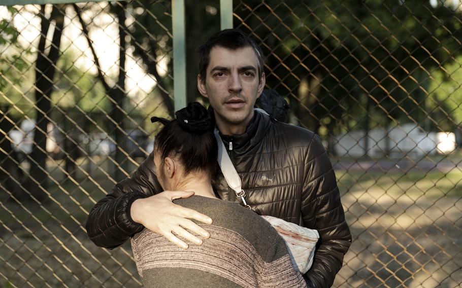 A neighbor cries on the shoulder of Yaroslav Riabchuk, whose wife was killed hours before when they couldn't access a bomb shelter in Kyiv on Thursday.