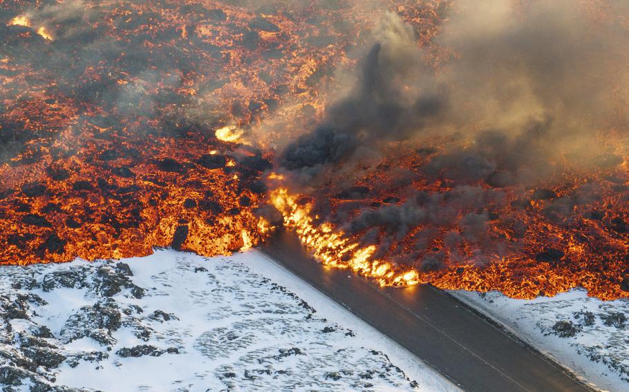 Lava crosses the main road to Grindavík and flows on the road leading to the Blue Lagoon, in Grindavík, Iceland, Thursday, Feb. 8, 2024. 