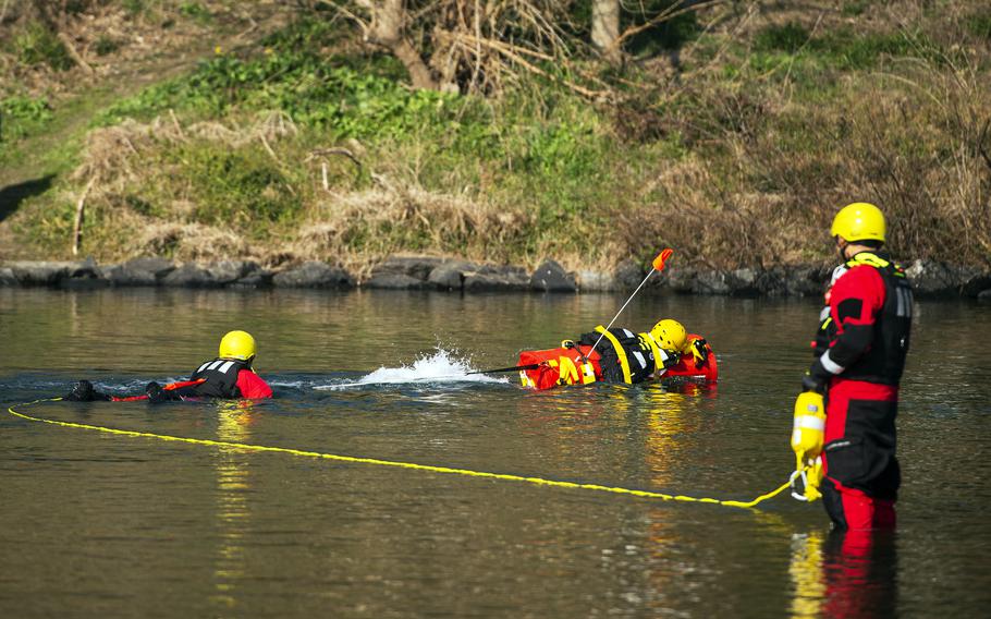 Firefighters demonstrate EMILY — the Emergency Integrated Lifesaving Lanyard — on the Nishiki River in Iwakuni, Japan, on Feb. 13, 2024.