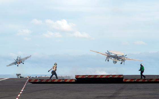 An F/A-18E Super Hornet, left, and an E-2D Hawkeye launch off the flight deck of the aircraft carrier USS Ronald Reagan in waters east of the Korean Peninsula, Sept. 28, 2022.
