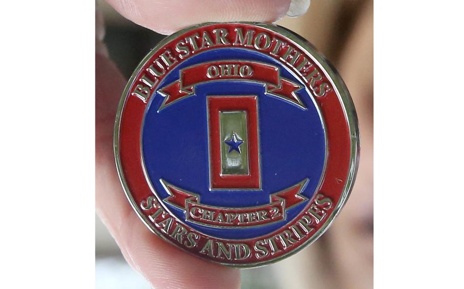 Susan O’Connor, a member of Blue Star Mothers, Rolling Thunder Chapter 2 and the Patriot Guard WWII, displays a challenge coin presented by Blue Star Mothers to WWII veteran Denver Conard in North Canton on Oct. 22, 2021. Conard is 100 years old.