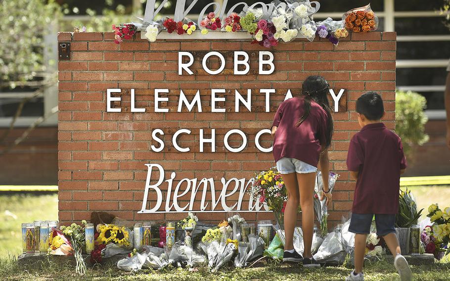 Family members who lost a sibling place flowers outside Robb Elementary School in Uvalde, Texas, on May 25, 2022. 