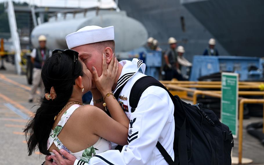 A sailor kisses his partner during a first-kiss ceremony.