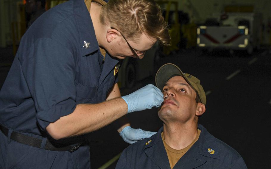 A sailor gets swabbed for COVID-19 testing aboard the USS Hershel “Woody” Williams in the Atlantic Ocean in June 2021. U.S. naval bases in Italy are waiting for COVID-19 test kits to arrive before starting mandatory testing of unvaccinated sailors, officials said Dec. 13.