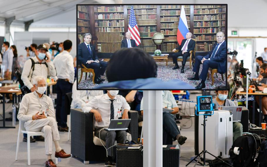 Journalists watch a broadcast feed of the start of the meeting between Vladimir Putin, Russia's president, second right, and U.S. President Joe Biden, second left, Sergei Lavrov, Russia's foreign minister, right, and Antony Blinken, U.S. secretary of state, left, in Geneva on June 16, 2021.