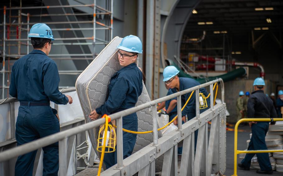 Seaman Alli Rambo carries a mattress off the USS Carl Vinson in San Diego on June 2, 2022. Sailors aboard Navy ships are still sleeping on uncomfortable mattresses, and that is one of the factors hampering the service's efforts to reduce fatigue in the fleet, the Government Accountability Office said in a new report.