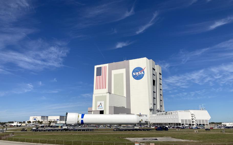 A caravan transports a Blue Origin New Glenn rocket first stage past the Vehicle Assembly Building at Kennedy Space Center, Fla., on Wednesday, Jan. 10, 2024.