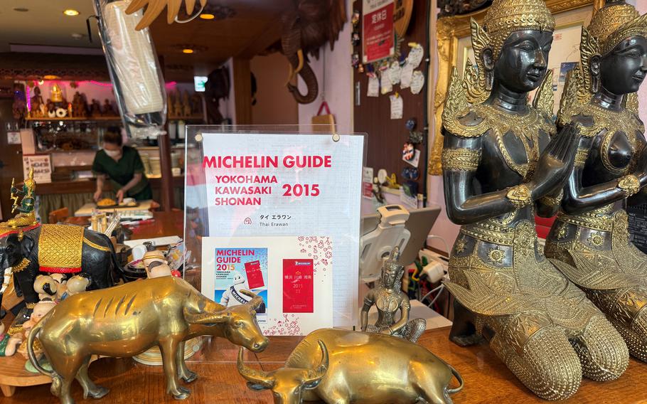 A sign amid various small statues and knickknacks says that the restaurant Thai Erawan received a Michelin star in 2015.