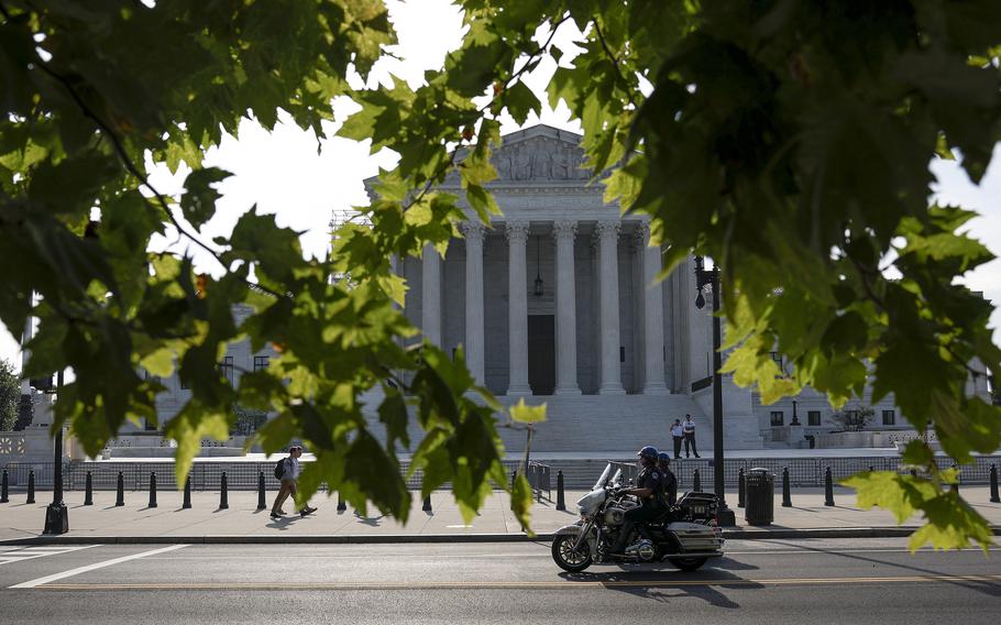 Police officers riding on motorcycles pass the U.S. Supreme Court Building on June 26, 2023, in Washington.