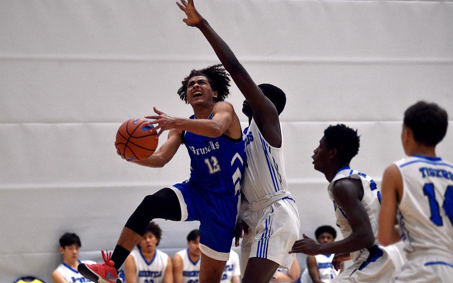 Brussels senior Damion Rogers drives to the hoop against Hohenfels freshman Joel Idowu during pool-play action of the DODEA European basketball championships on Feb. 14, 2024, at the Wiesbaden Sports and Fitness Center on Clay Kaserne in Wiesbaden, Germany.