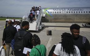 Passengers wait to board a World Atlantic plane at Toussaint-Louverture International Airport in Port-au-Prince, Haiti, after it reopened on May 20, 2024.