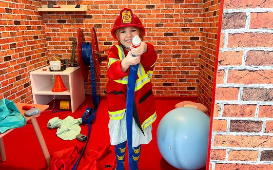 A young girl enjoys playing firefighter during a visit to Little Kids Town in Eppstein, Germany, on March 22, 2025. 