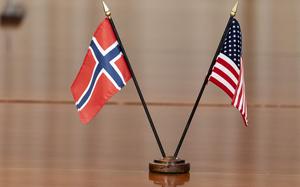 Small American and Norwegian flags are displayed together on a table.