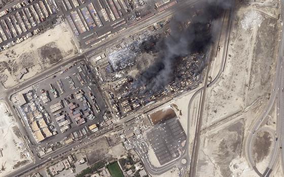 An aerial photo of smoke rising from an area with cargo containers.