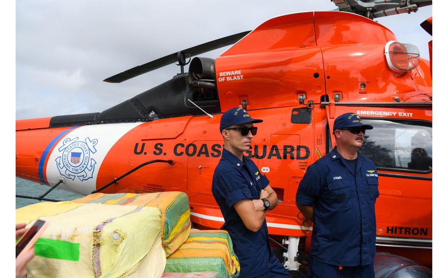 U.S. Coast Guard personnel stand next to a helicopter on the deck of Cutter James as they offload approximately $1.06 Billion in cocaine, marijuana at the Port Everglades in Fort Lauderdale, Fla., on Feb. 17, 2022. 