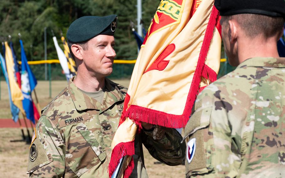 Col. Reid E. Furman takes the colors of U.S. Army Garrison Rheinland-Pfalz during a change-of-command ceremony in Kaiserslautern, Germany, on Friday, July 22, 2022.