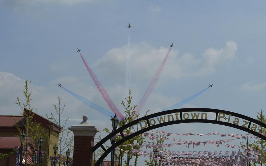 Jets fly in unison while releasing colored smoke.