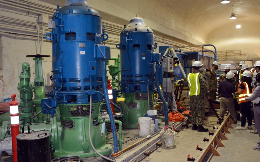 Navy officials speak with news reporters near pumps inside the Red Hill well-shaft room in Honolulu, Hawaii, Friday, Jan. 28, 2022.